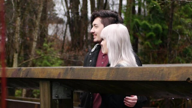 橋の上で会話を楽しみながら景色を眺めるカップル