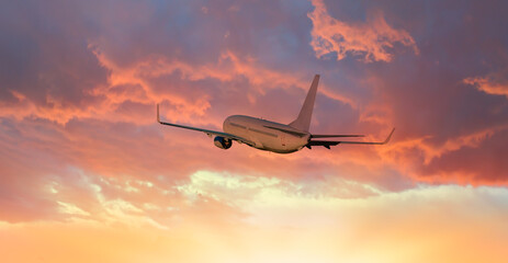 Fototapeta na wymiar Airplane flying above tropical sea at amazing sunset