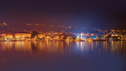 Fototapeta premium Resort town of Fethiye city lights reflection on the water with lot of boat - Fethiye, Turkey