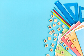 Bright multicolored school supplies, stationery on a blue background. A group of school subjects....