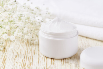Fototapeta na wymiar jar of face skin care cream for moisturizing and relaxing facial skin, on a white table.