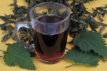 Mug de tisane d'orties en gros plan sur fond jaune