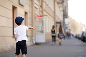 boy with toy airplane in the city.