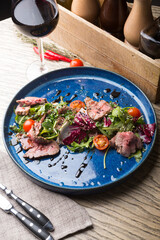 Roastbeef salad served with glass of red wine