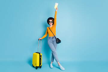 Full length body size photo girl keeping documents tickets in airport terminal ready to travel isolated on bright blue color background