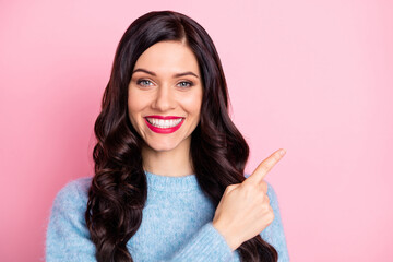 Portrait of cheerful pretty girl beaming smile indicate finger empty space isolated on pink color...
