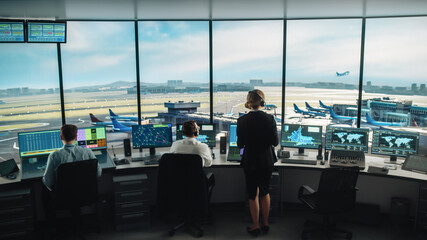 Diverse Air Traffic Control Team Working in a Modern Airport Tower. Office Room is Full of Desktop Computer Displays with Navigation Screens, Airplane Flight Radar Data for Controllers.