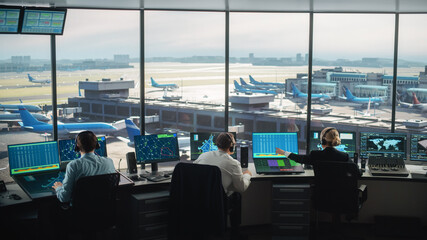 Diverse Air Traffic Control Team Working in a Modern Airport Tower. Office Room is Full of Desktop...