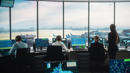 Diverse Air Traffic Control Team Working in a Modern Airport Tower. Office Room is Full of Desktop...