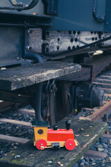 wooden toy train on steps of an historic big train