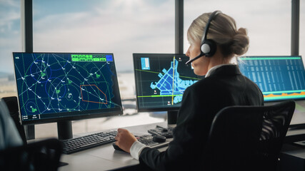 Female Air Traffic Controller with Headset Talk on a Call in Airport Tower. Office Room is Full of Desktop Computer Displays with Navigation Screens, Airplane Flight Radar Data for the Team. © Gorodenkoff
