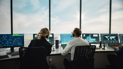Diverse Air Traffic Control Team Working in a Modern Airport Tower. Office Room is Full of Desktop...