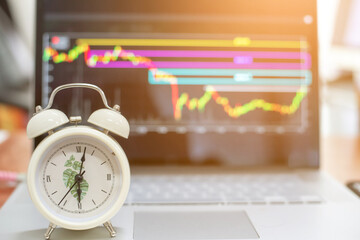 The alarm is telling the time and giving an alarm. The backdrop is a chart of cryptocurrency trading