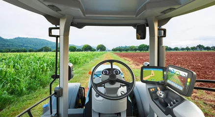 Zelfklevend Fotobehang Autonome tractor die in maïsveld werkt, Toekomstige technologie met slim landbouwlandbouwconcept © kinwun