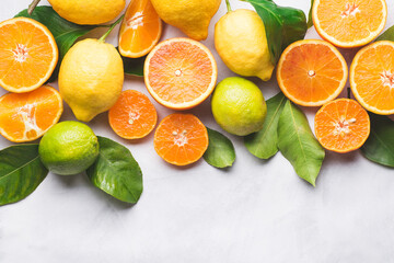 Fototapeta na wymiar Citrus fruits background. Oranges, oranges Tarocco, lime, lemon and mandarins with green leaves. Healthy food and drinks concept, flat lay, copy space. Organic citrus fruits