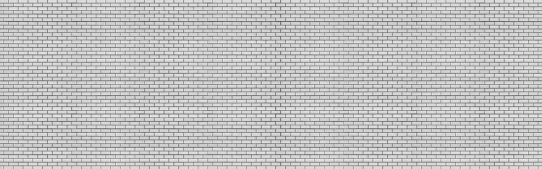 Long brick wall of light gray bricks. Abstract background for design. Backdrop for text. Copy space. Panorama.
