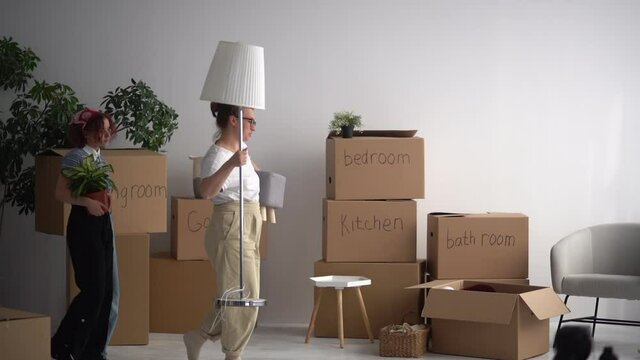 Mother and daughter enjoy the new apartment, carry boxes of things during relocation. Buying a new home, minimalism and decluttering concept