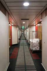 Corridor of a cruise ship with cleaners changing towels in the cabins