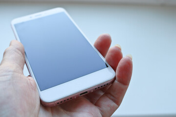 Woman plugging a USB cable into a smartphone connector to charge. Special charging connector for phone.