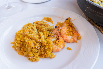 Juicy rice with onion and shrimps on a plate