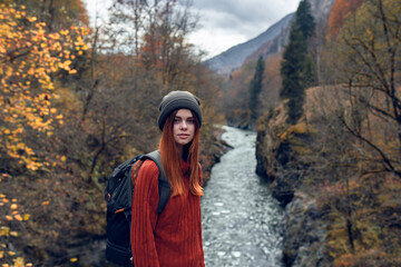 woman hiker with backpack in the mountains autumn forest river landscape