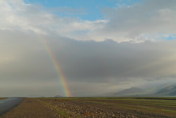the beginning of a rainbow on a beautiful mountain sunny landscape