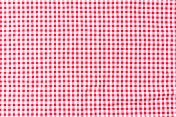 Tablecloth checkers picnic for the weekend. Abstract background fabric red and white placed on a white background top view, flat lay.