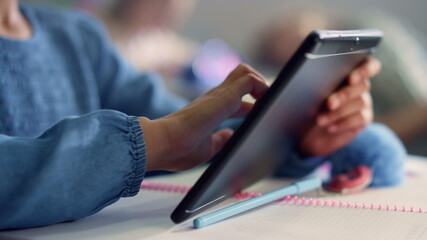 Student hand using digital tablet. Girl doing class work on tablet computer