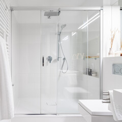 Spacious shower behind glass sliding doors