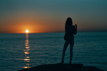 silhouette of woman on the sea at sunset and skyline beach sky