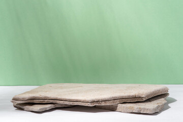 Background for cosmetic products of natural green color. Stone podium on a green background. Front...