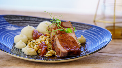 Tataki de ternera con verduras y pure de patata servidos en un plato de cerámica
