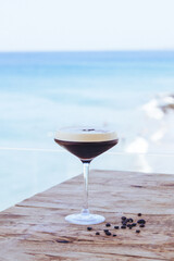 Cocktail frio de café sobre base de madera y fondo del océano