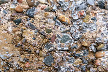 Old concrete wall for the backdrop. Cracks, paint residues, colored stones.