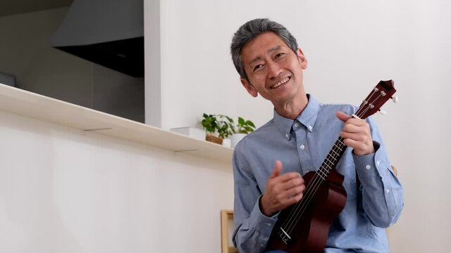 ウクレレを楽しそうに演奏するシニア男性