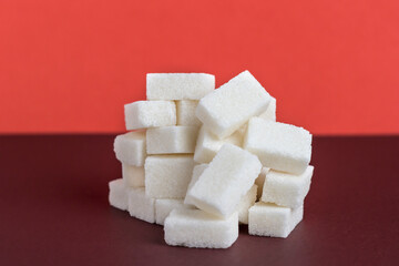 Sugar lumps in a glass with a tube. Dangerous food.