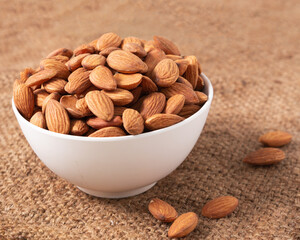 Almond nuts in a white bowl wooden background, selective focus.front view.close-up.