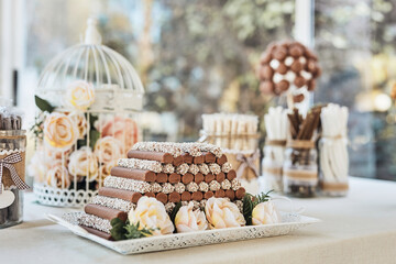 Black and white chocolate sweet table with handmade chocolates, cake pops, roses and decorations at an elegant wedding reception. Shot with natural light