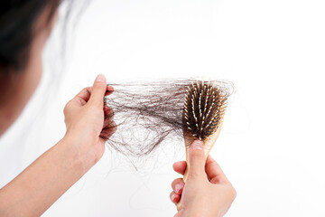 A woman's hand grabs the missing hair on the brush, isolated on white background. Hair that has...