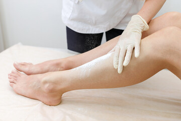 hands close-up poured the powder on the client's feet. foot shugaring