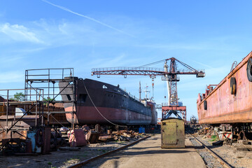 Fototapeta na wymiar Cargo vessel ashore on ship repairing yard. Summer time.