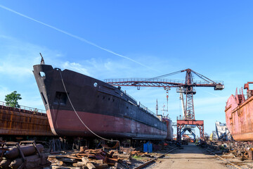 Cargo vessel ashore on ship repairing yard. Summer time.