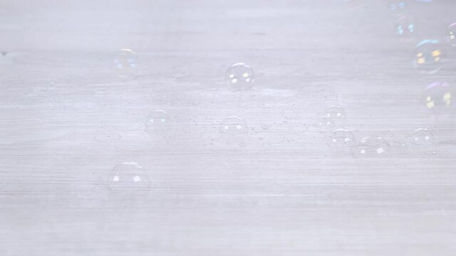 Rainbow soap bubbles on a white wooden table. Relaxation and imagination concept, childhood