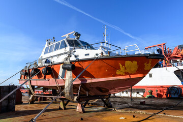 Small sized vessel ashore on ship repairing yard. Summer time.