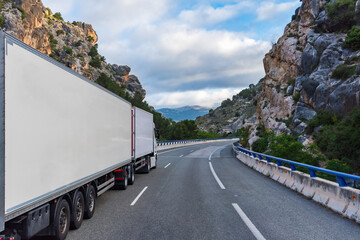 Mega truck or euro modular system (EMS) with refrigerated semi-trailers driving through a gorge.