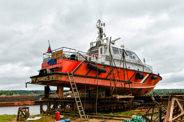 Small sized vessel ashore on ship repairing yard. Summer time.