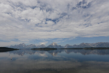 Scenic view of a lake with mountains in the background and lake reflections in Grand Teton National Park on a cloudy day