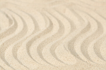 Fototapeta na wymiar wavy sand texture in narrow focus and blurring. receding perspective
