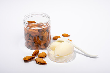 Sweet almond butter and natural almonds on white background.