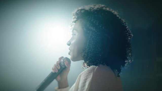 CU Portrait of Black African American young female comedian performing her stand-up monologue on a stage of a small venue. Shot with ARRI Alexa Mini LF with 2x anamorphic lens